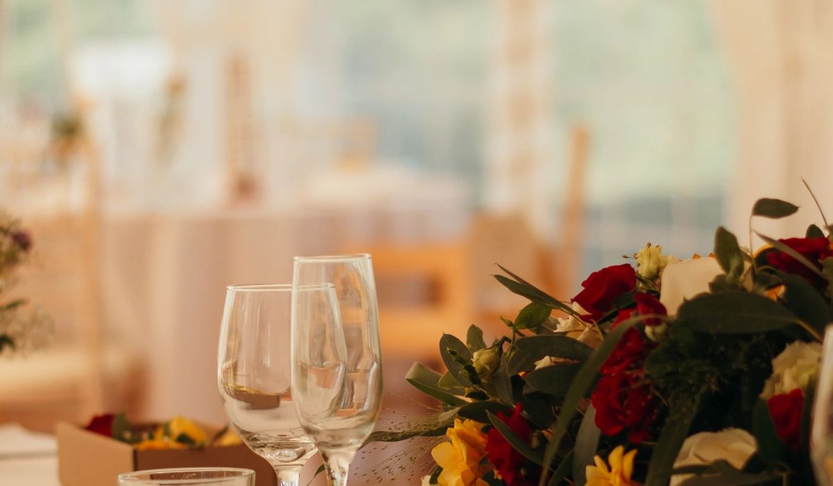 Mesa elegante con copas de vino y arreglo floral